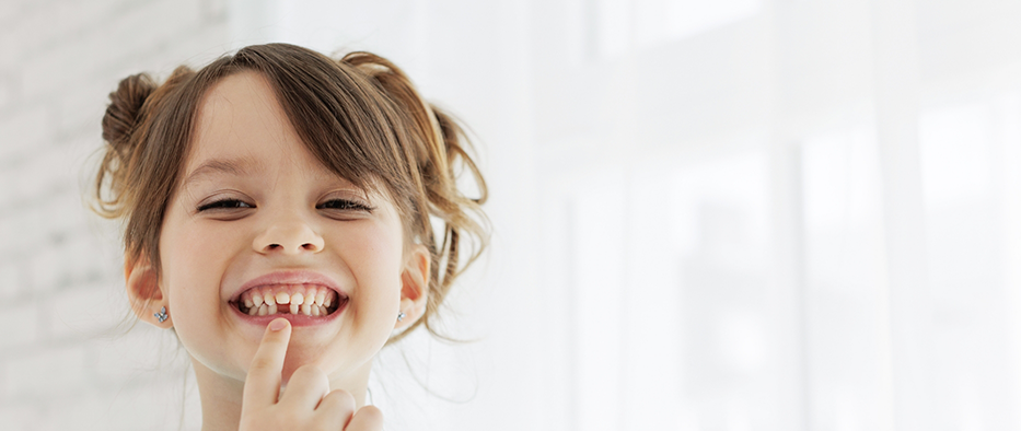 Close up of little girl with a lost tooth