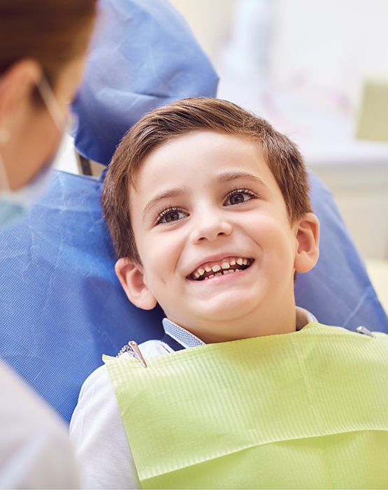 Little boy looking up at his dentist and smiling