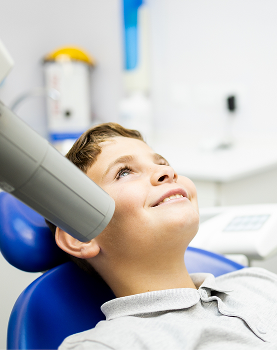 Young boy sitting back in chair smiling