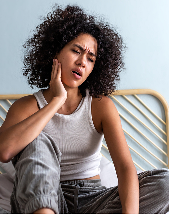Woman sitting up in bed with a toothache