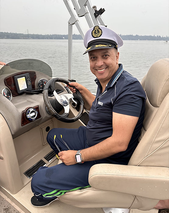 Doctor Musbah wearing a captain's hat and piloting a boat