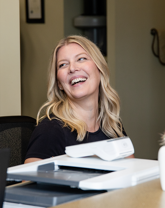Woman with blonde hair sitting and smiling