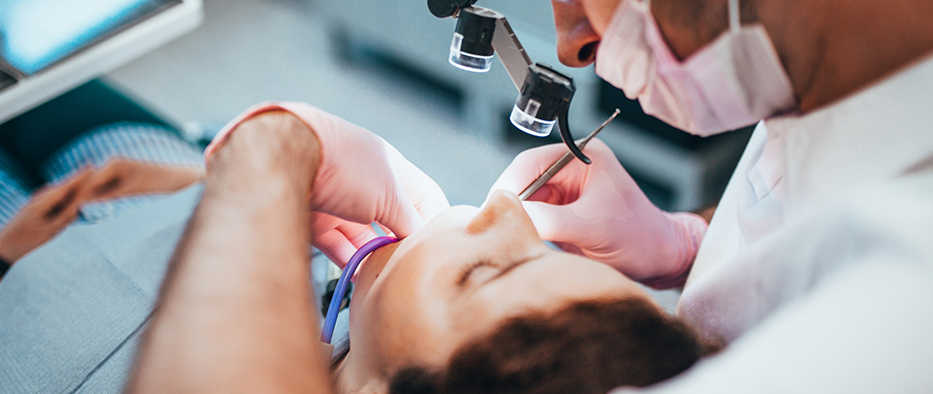 Patient leaning back while dentist performs root canal treatment