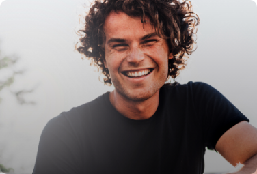 Man in black shirt smiling outside
