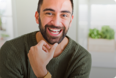 Smiling man with beard rubbing his chin