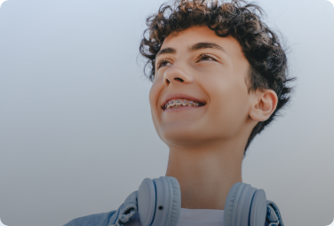Man with curly hair and braces