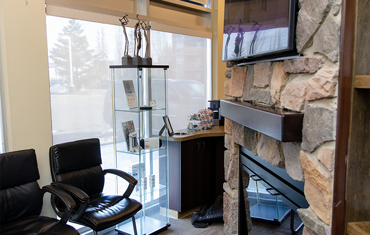 Glass case, fireplace, and chairs in dental office